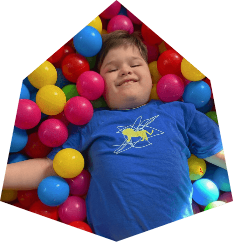 A boy laying on the floor with balls